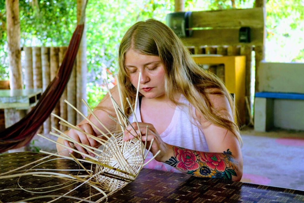 A guest weaving a basket from strips of cane at Palmento Grove