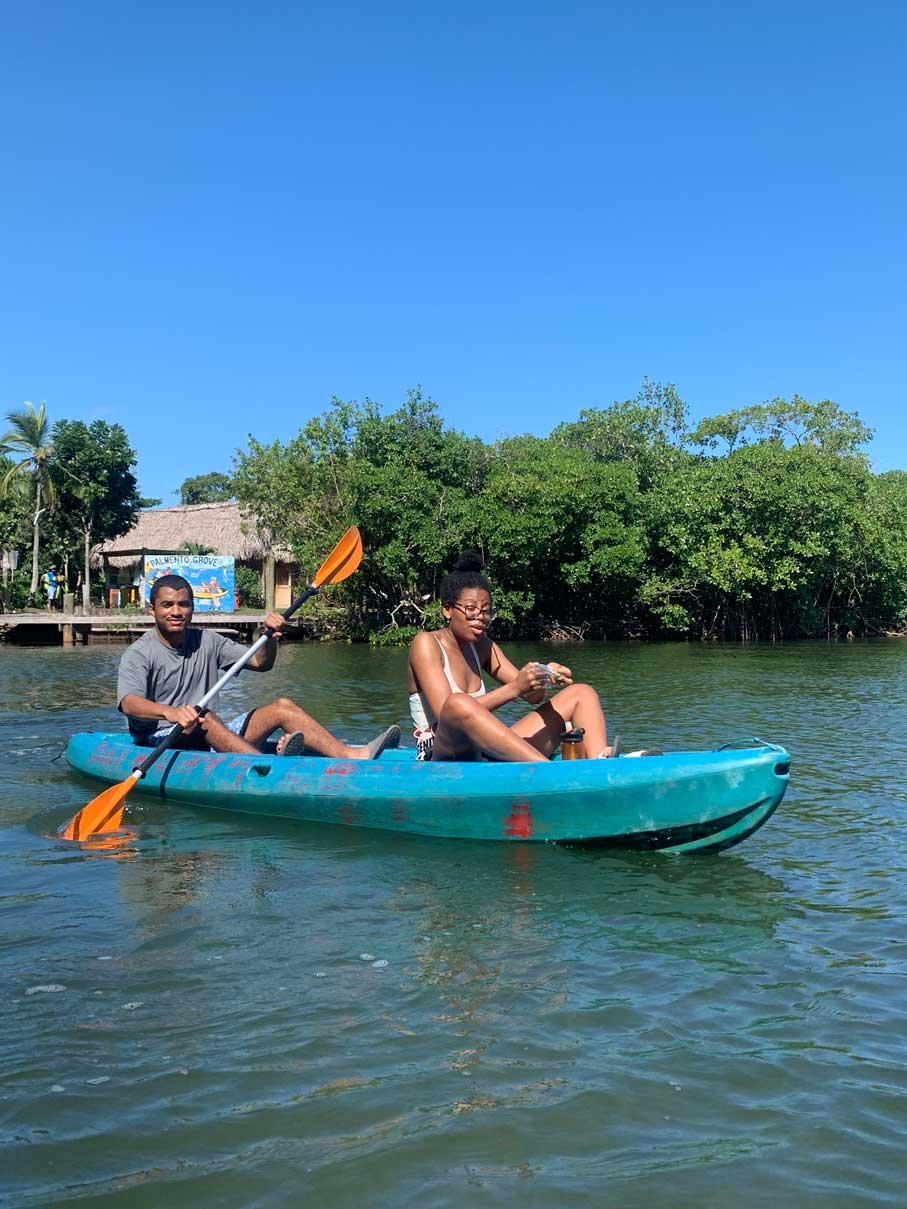 Two guests in a turquoise kayak on the lagoon near Kalipuna Island, Hopkins, Belize