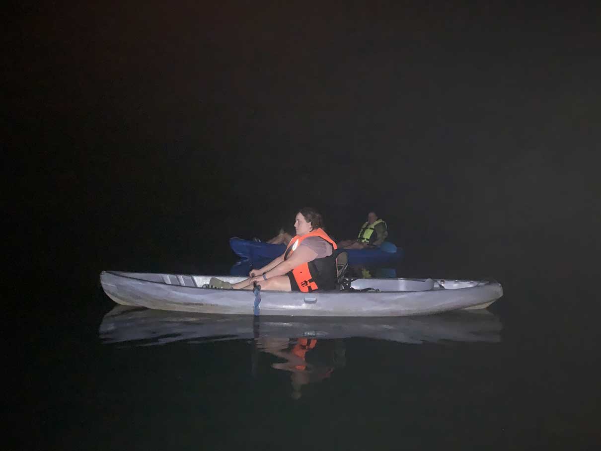 Lone kayaker on the dark lagoon at night near Hopkins, Belize