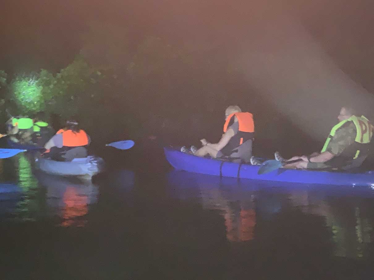 Kayaks lit up on the bioluminescent lagoon at night near Hopkins, Belize