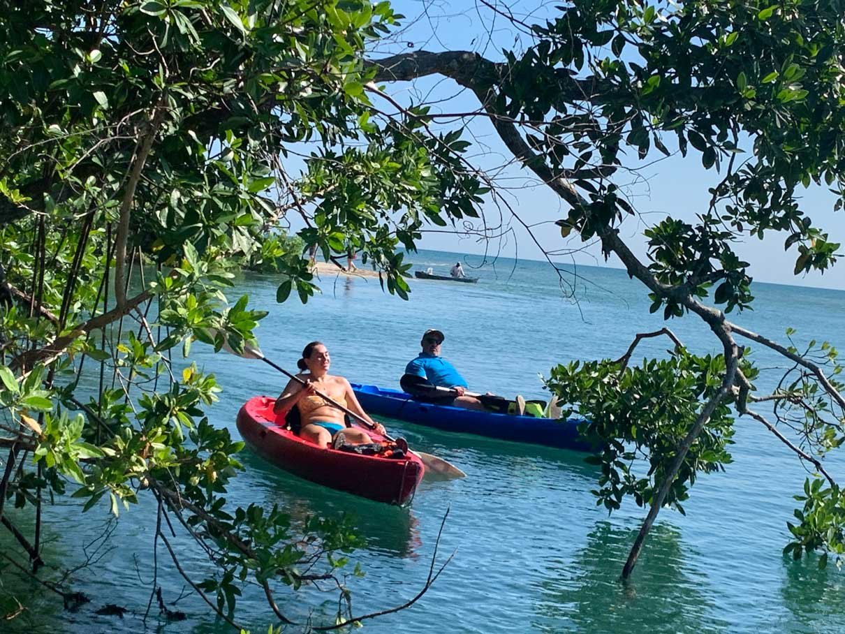 Guests paddling kayaks on Freshwater Creek Lagoon at Palmento Grove, Hopkins, Belize