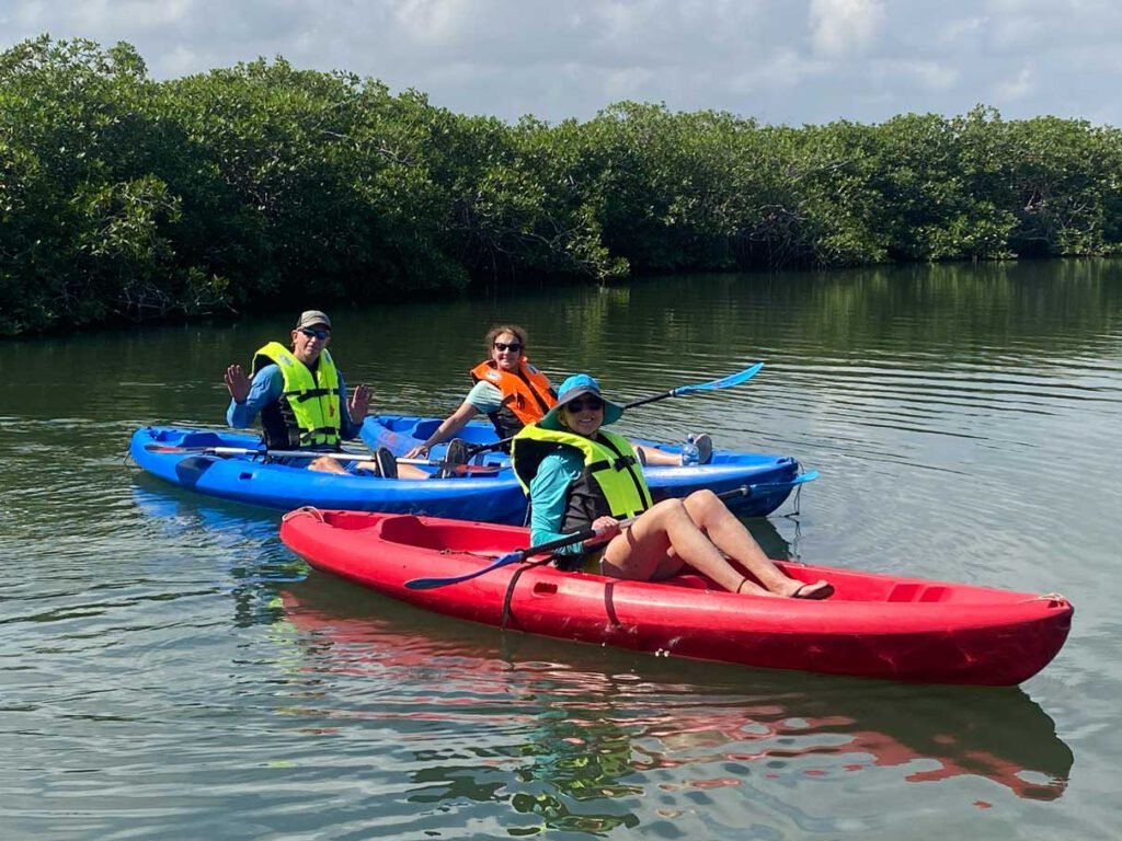 Guests in red and blue kayaks on Fresh Water Creek Lagoon, Hopkins, Belize