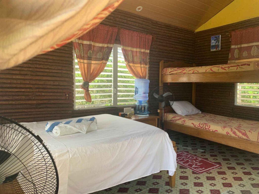 Bunk beds and a double bed inside a guest cabin at Palmento Grove, Hopkins, Belize