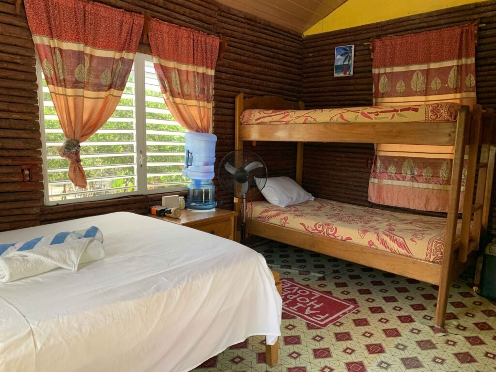 Inside a guest cabin at Palmento Grove: a queen bed and bunk beds, sleeping four