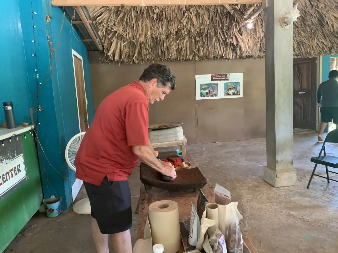 Guest grinding cacao on a stone at the Maya chocolate centre, Belize