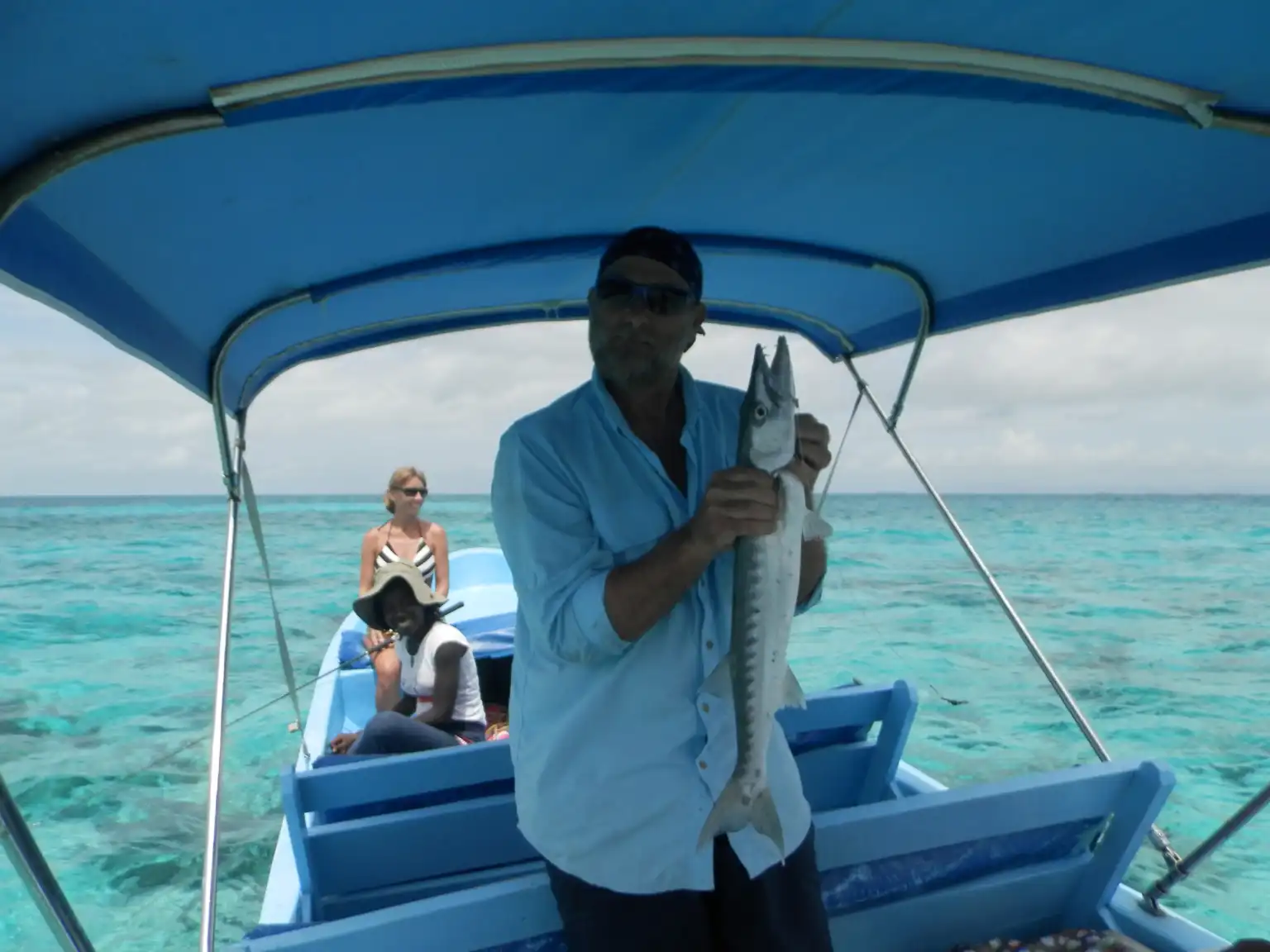 Guest holding a barracuda on a fishing boat off Hopkins, Belize