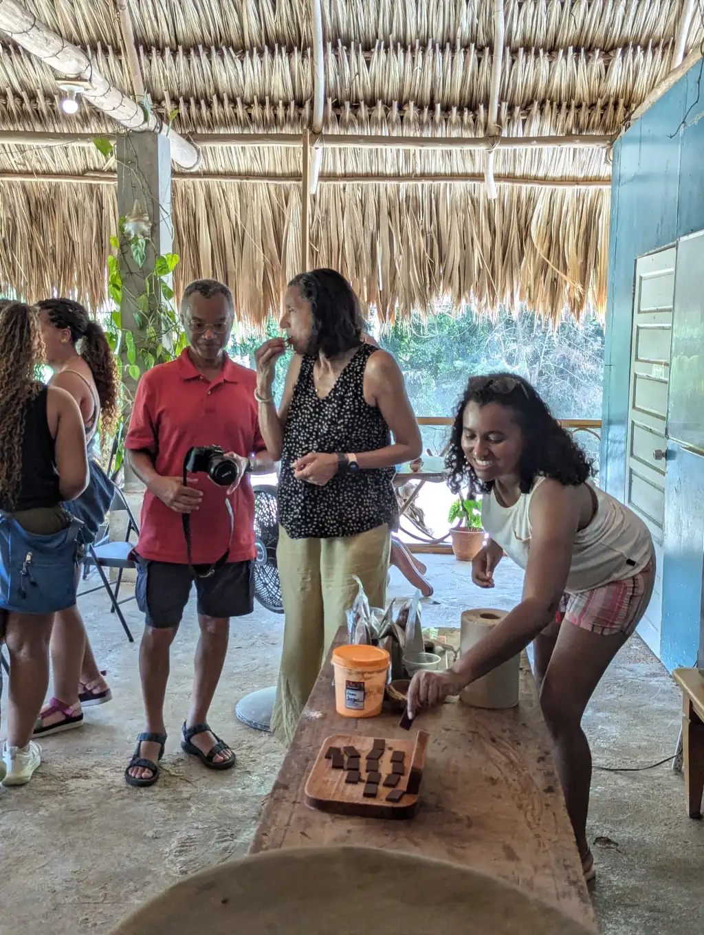 Guests tasting chocolate under a thatched roof at the Maya chocolate centre, Belize