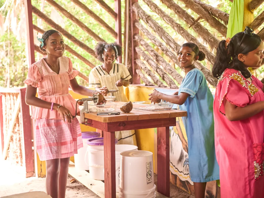 A Garifuna cook grating coconut in the open kitchen at Palmento Grove, Hopkins, Belize