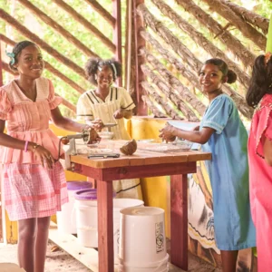 A Garifuna cook grating coconut in the open kitchen at Palmento Grove, Hopkins, Belize