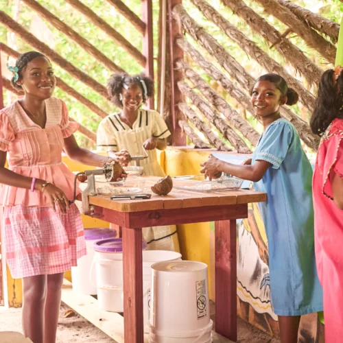A Garifuna cook grating coconut in the open kitchen at Palmento Grove, Hopkins, Belize