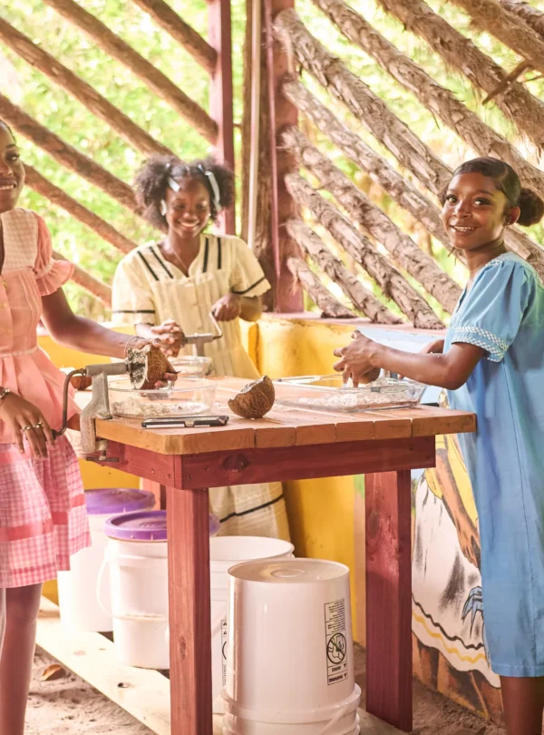 A Garifuna cook grating coconut in the open kitchen at Palmento Grove, Hopkins, Belize