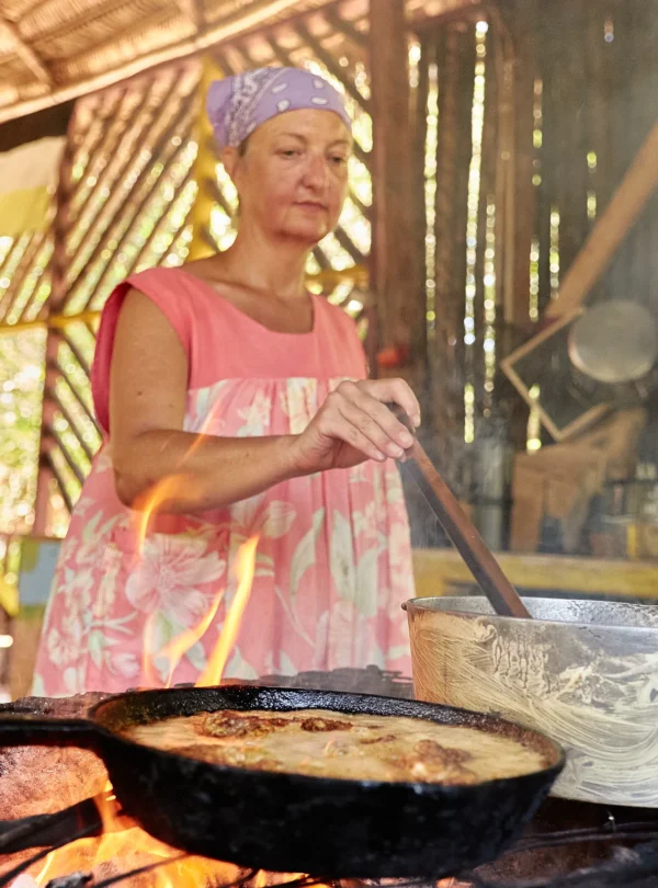 A cook frying over the open hearth in the Palmento Grove kitchen, Hopkins, Belize