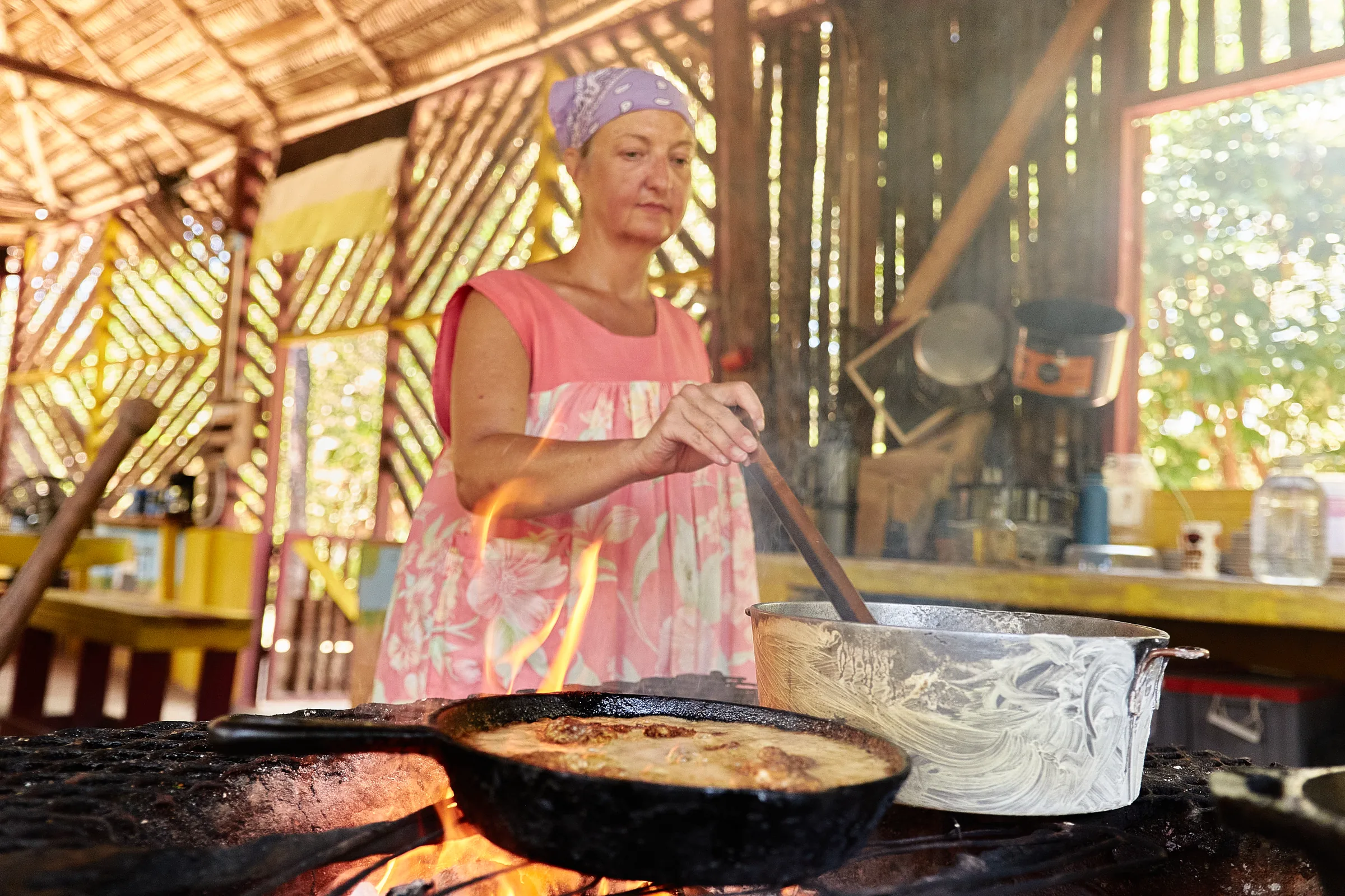 A cook frying over the open hearth in the Palmento Grove kitchen, Hopkins, Belize