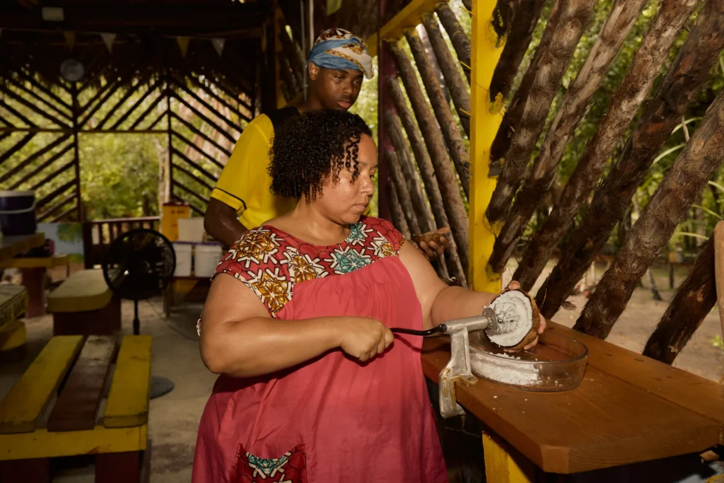 Guest grating cassava on a board during a Garifuna cooking class at Palmento Grove, Hopkins, Belize