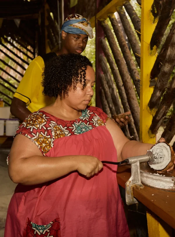 Guest grating cassava on a board during a Garifuna cooking class at Palmento Grove, Hopkins, Belize
