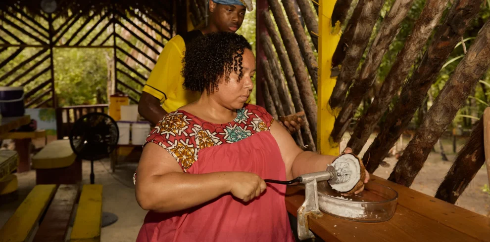 Guest grating cassava on a board during a Garifuna cooking class at Palmento Grove, Hopkins, Belize