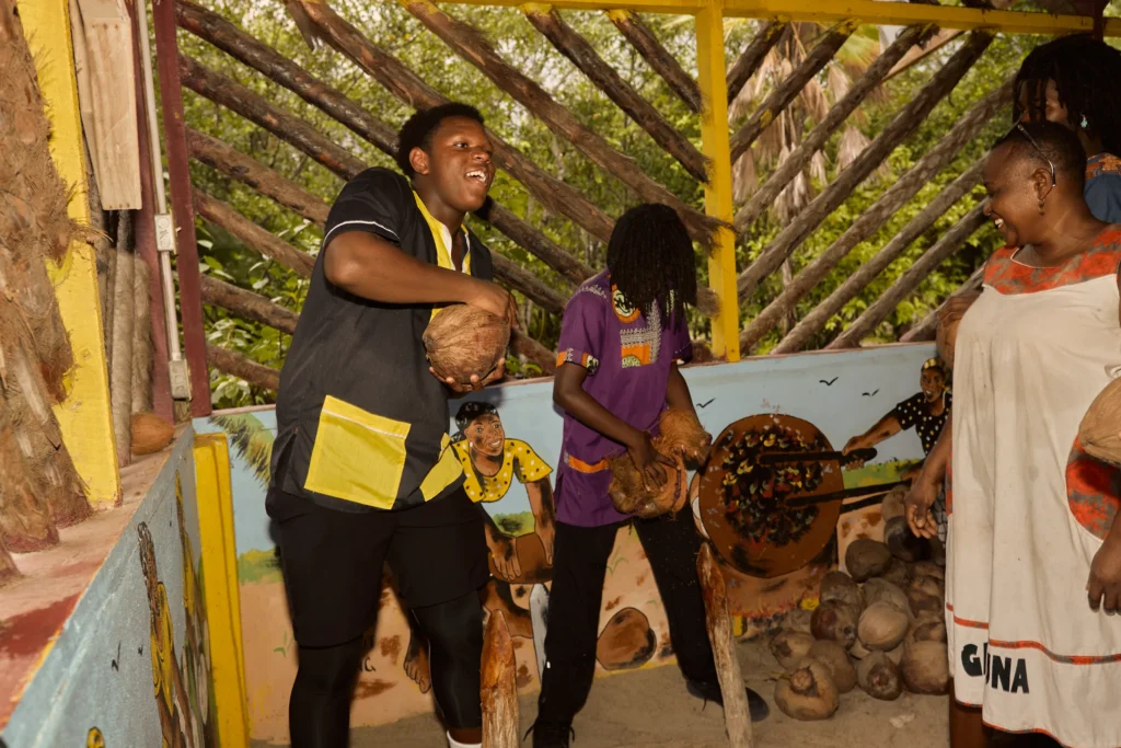 Guests husking coconuts together during a Garifuna cultural and culinary day at Palmento Grove