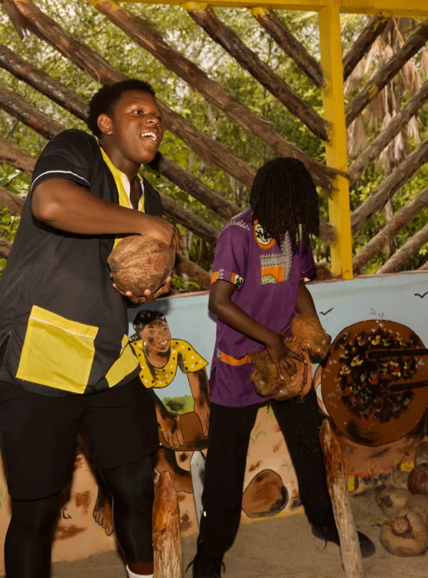 Guests husking coconuts together during a Garifuna cultural and culinary day at Palmento Grove