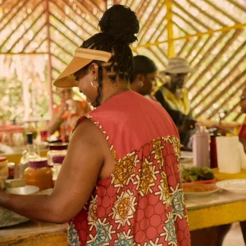 Plating the finished Garifuna meal on the long kitchen table at Palmento Grove, Hopkins, Belize