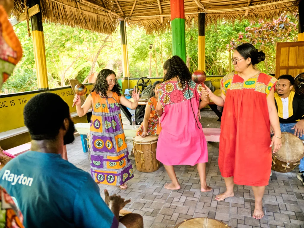 Guests dancing barefoot as Garifuna drummers play behind them at Palmento Grove, Hopkins, Belize
