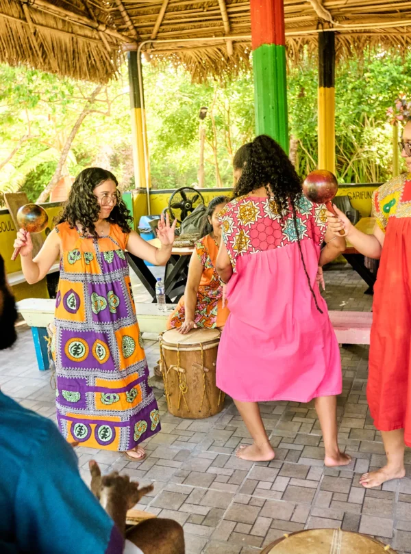Guests dancing barefoot as Garifuna drummers play behind them at Palmento Grove, Hopkins, Belize