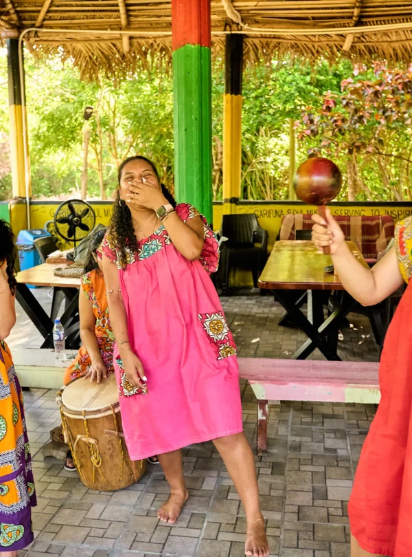 Guests dancing with maracas while drummers play in the Buiti Achuluruni pavilion at Palmento Grove, Hopkins, Belize