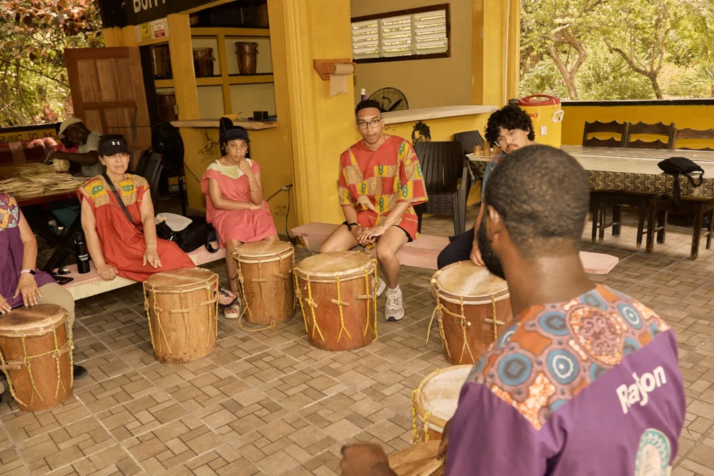 Guests seated at Garifuna drums during a drumming session at Palmento Grove, Hopkins, Belize