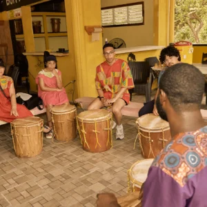 Guests seated at Garifuna drums during a drumming session at Palmento Grove, Hopkins, Belize