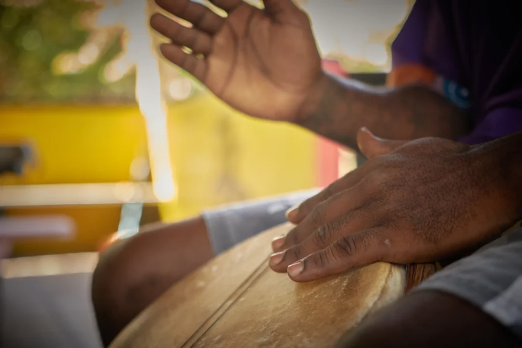 Hands playing a Garifuna drum at Palmento Grove, Hopkins, Belize