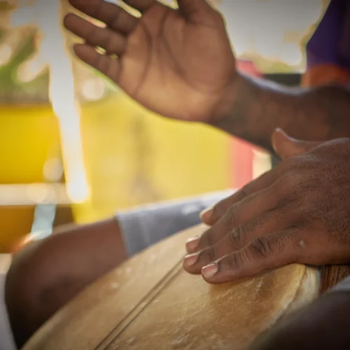 Hands playing a Garifuna drum at Palmento Grove, Hopkins, Belize