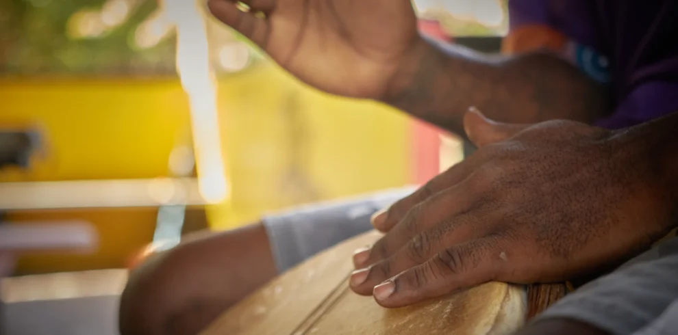 Hands playing a Garifuna drum at Palmento Grove, Hopkins, Belize