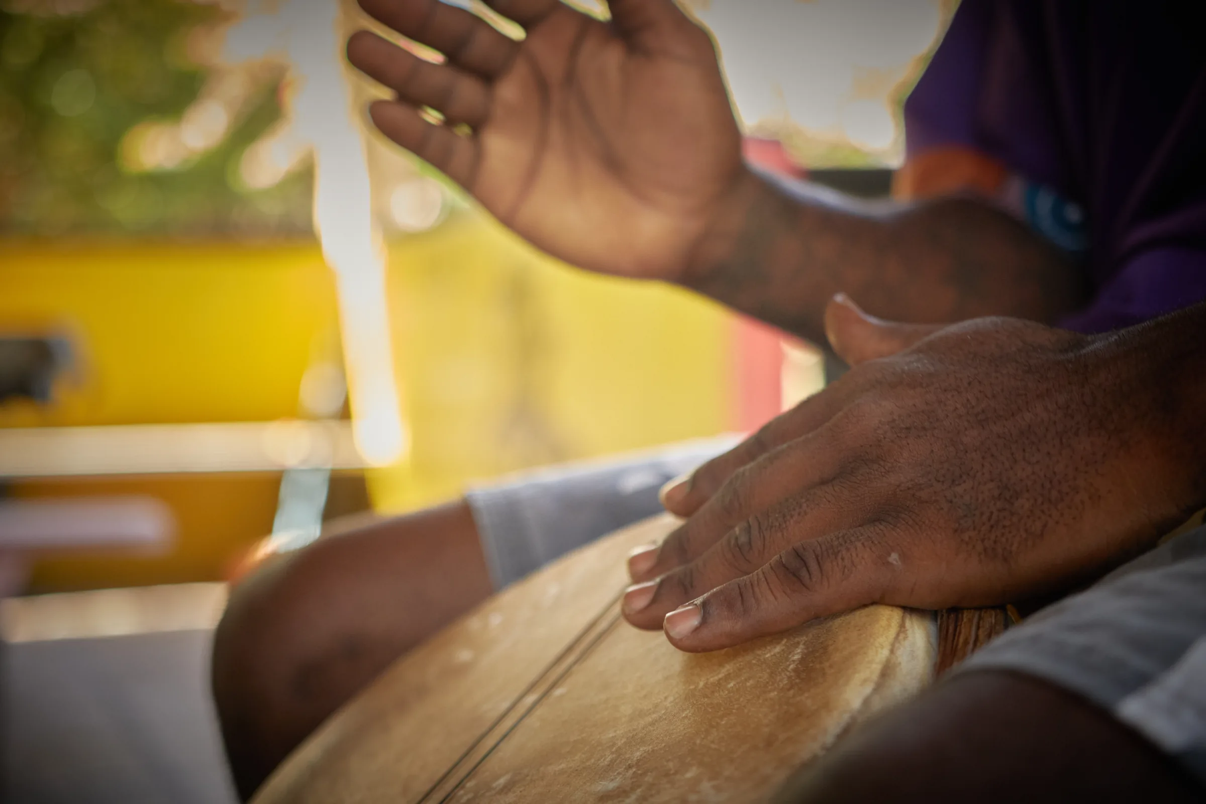 Hands playing a Garifuna drum at Palmento Grove, Hopkins, Belize