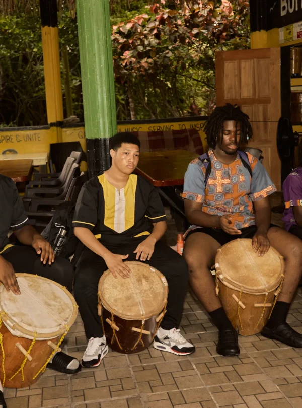 A Garifuna drumming and dancing session with guests playing the drums at Palmento Grove
