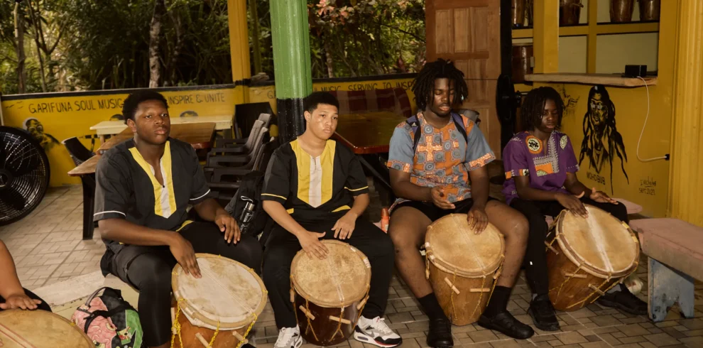 A Garifuna drumming and dancing session with guests playing the drums at Palmento Grove