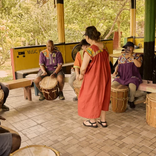 A guest playing Garifuna maracas during a drumming session at Palmento Grove, Hopkins, Belize