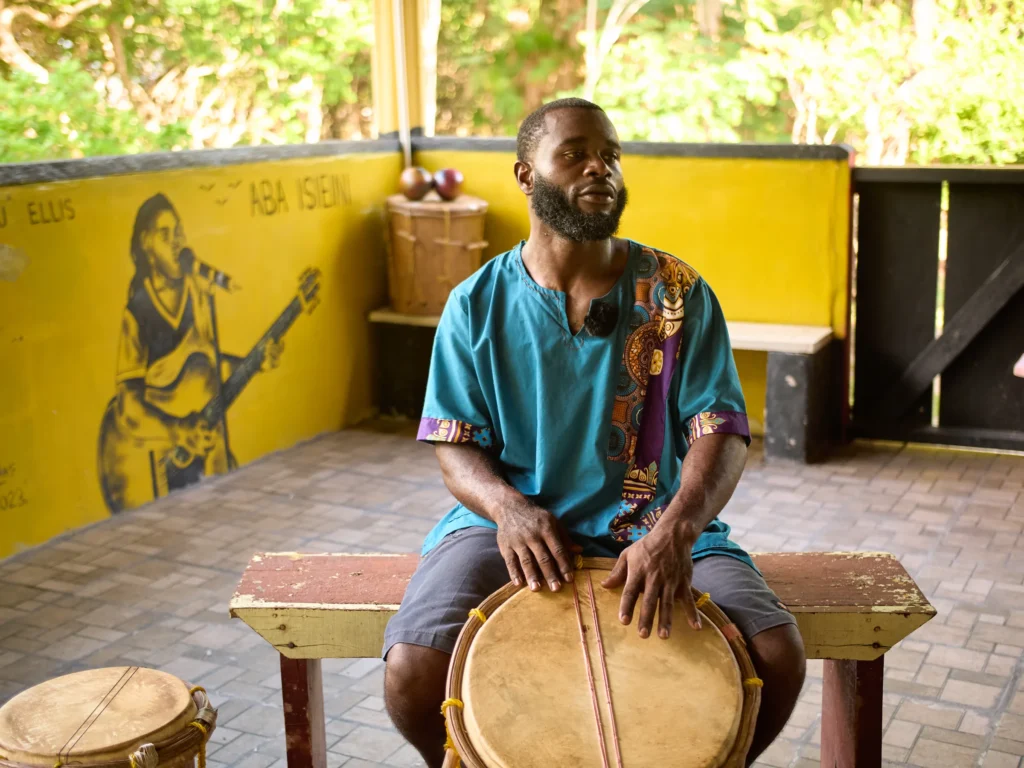 Rayton Martinez, the drumming instructor, seated at a Garifuna drum in the music pavilion at Palmento Grove, Hopkins, Belize