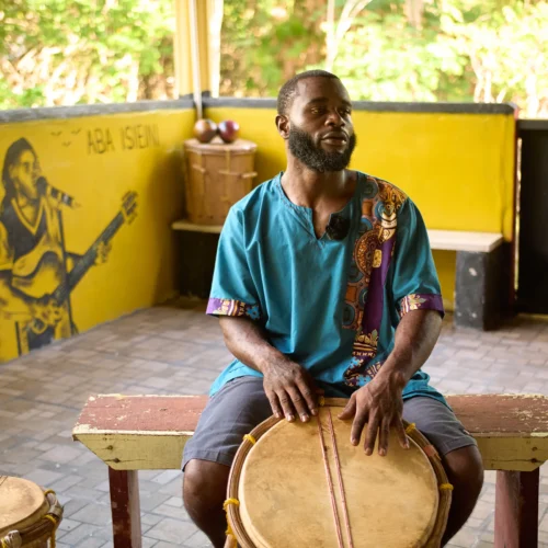 Rayton Martinez, the drumming instructor, seated at a Garifuna drum in the music pavilion at Palmento Grove, Hopkins, Belize