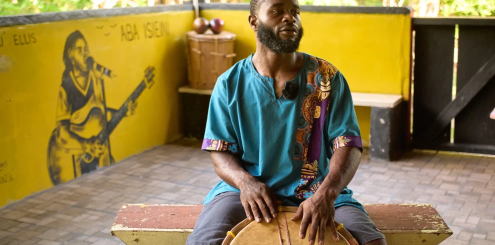 Rayton Martinez, the drumming instructor, seated at a Garifuna drum in the music pavilion at Palmento Grove, Hopkins, Belize