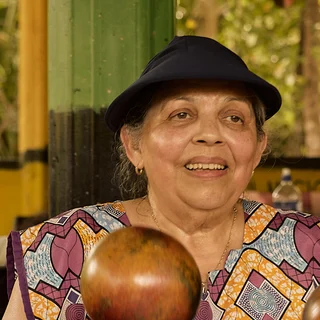 An elder with a sísira in the music pavilion