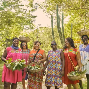 A group carrying hand-woven baskets in the garden at Palmento Grove, Hopkins, Belize