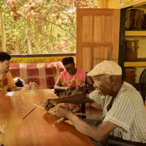 Guests learning basket weaving at the long table at Palmento Grove, Hopkins, Belize