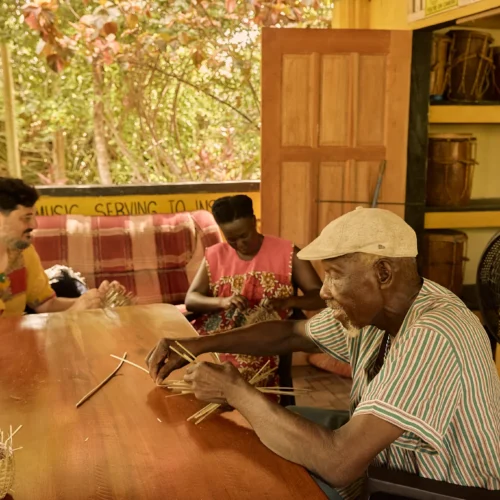 Guests learning basket weaving at the long table at Palmento Grove, Hopkins, Belize