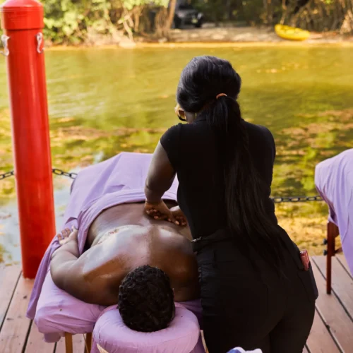 Massage in progress on the deck at Palmento Grove, with the mangrove lagoon behind