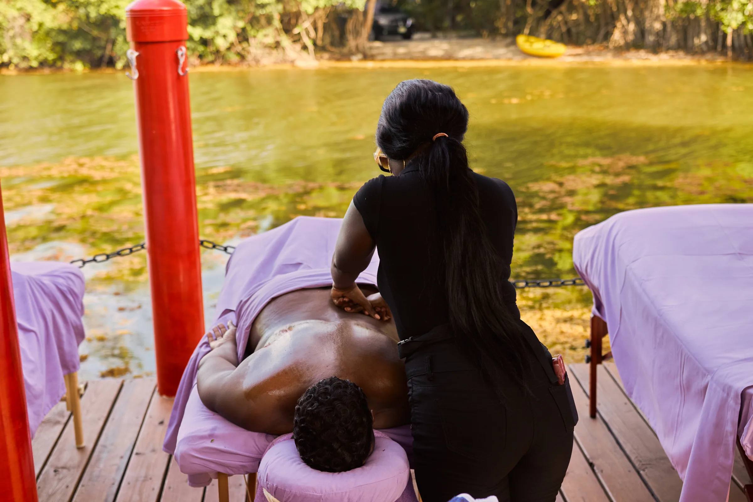 Massage in progress on the deck at Palmento Grove, with the mangrove lagoon behind
