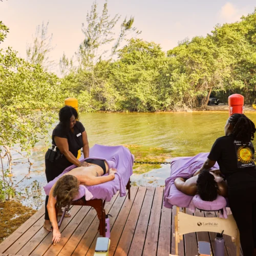 Two massage tables set on the deck beside the mangrove lagoon at Palmento Grove, Hopkins, Belize